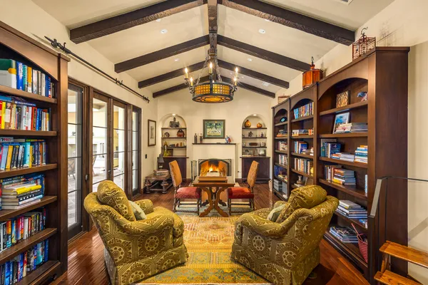 a view of a livingroom with bookshelf and furniture