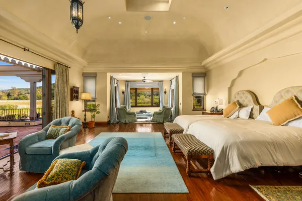 a spacious bedroom with a bed and glass windows