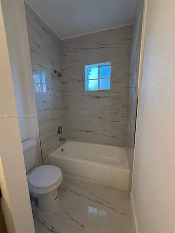 a bathroom with a toilet and a bath tub