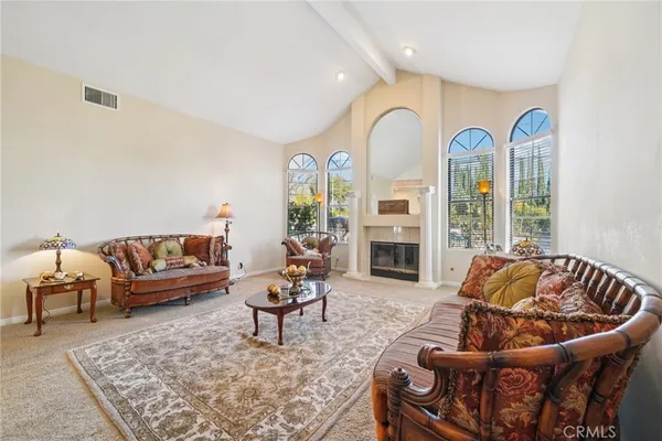 a living room with fireplace furniture and a rug