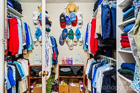 a view of walk in closet with clothes