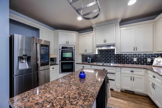 a living room with furniture large window and wooden floor