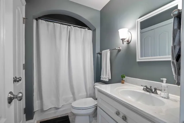 a living room with pool table furniture and a ceiling fan