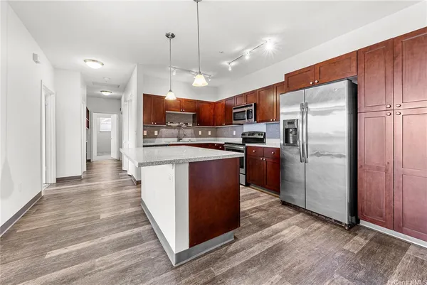 a kitchen with stainless steel appliances granite countertop a refrigerator a stove a sink and a oven