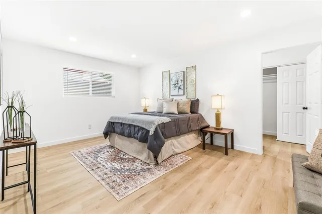 a bedroom with a bed lamp and a potted plant