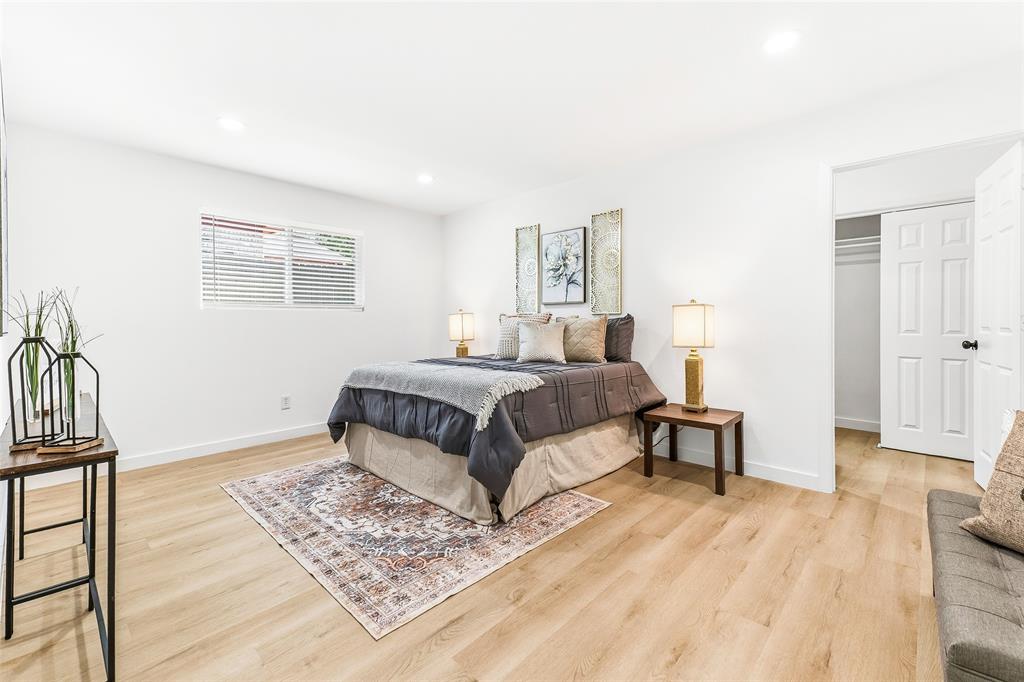 902 Warrington Court Arlington, TX 76014 - Photo 11 of 30 a bedroom with a bed lamp and a potted plant