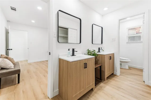 a spacious bathroom with a double vanity sink mirror and toilet