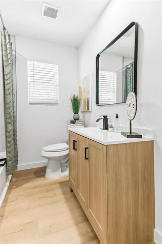a bathroom with a toilet sink and mirror
