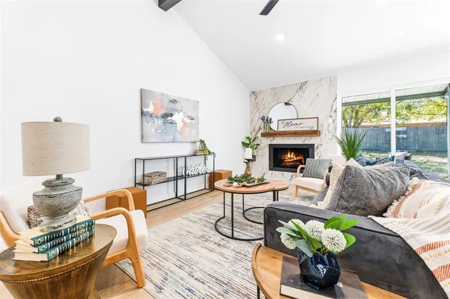a living room with furniture fireplace and a large window