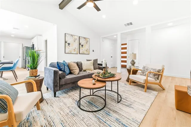 a living room with furniture a rug and a chandelier
