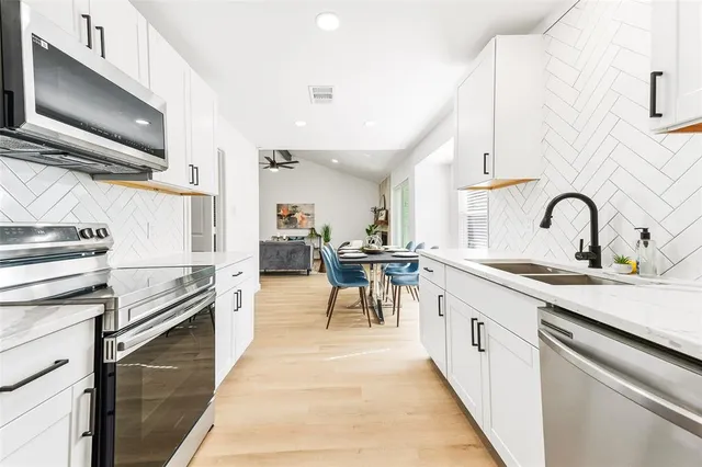 a kitchen with stainless steel appliances granite countertop a sink and cabinets
