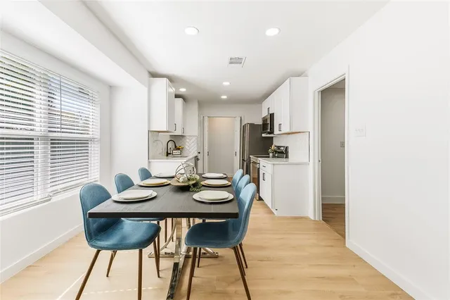 a kitchen with a dining table chairs and refrigerator