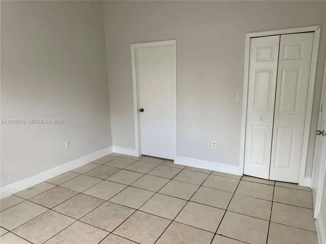 a view of an empty room and chandelier fan