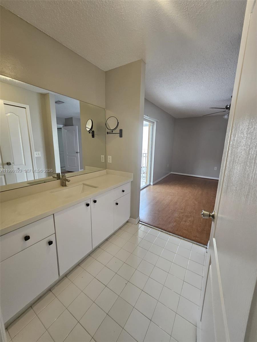 2527 West 76th Street, Unit 208 Hialeah, FL 33016 - Photo 13 of 24 a spacious bathroom with a granite countertop sink and a mirror