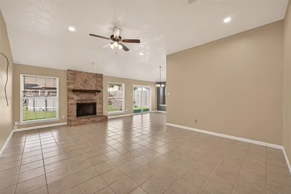 an empty room with windows and fireplace