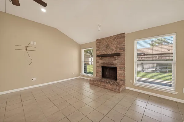 a view of an empty room with a fireplace and a window