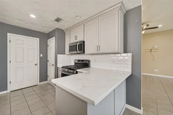 a kitchen with a sink a stove and cabinets