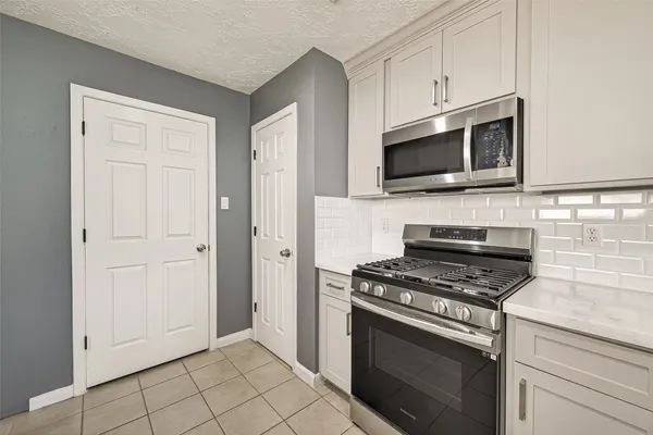 a kitchen with cabinets stainless steel appliances and a window