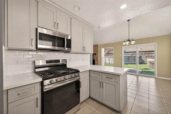 a kitchen with cabinets stainless steel appliances and a counter space