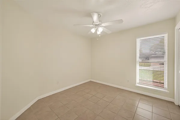 an empty room with a window and a fan