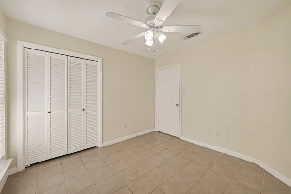 a view of an empty room with a ceiling fan