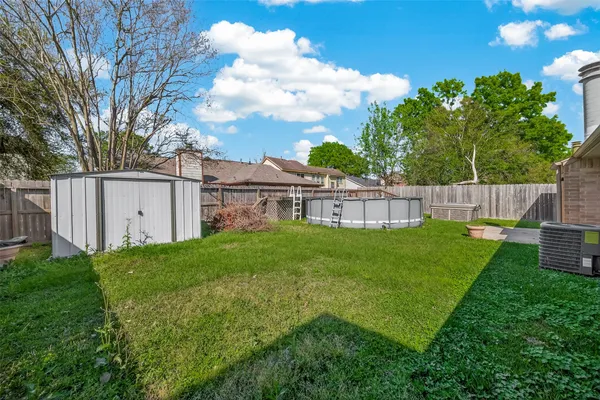 a view of a house with a backyard and a tree