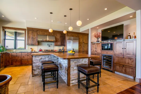 a kitchen with stainless steel appliances granite countertop a sink and a living room