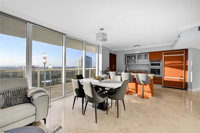 a dining room with furniture and a large window