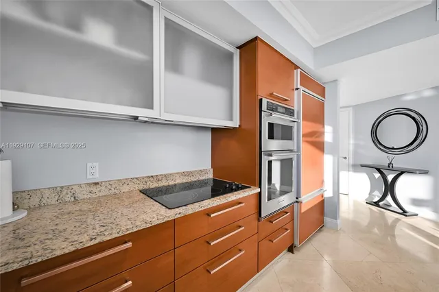 a kitchen with granite countertop a sink a stove and cabinets