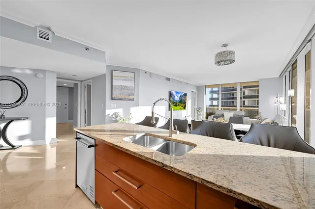a kitchen with granite countertop a sink a stove and a wooden cabinets