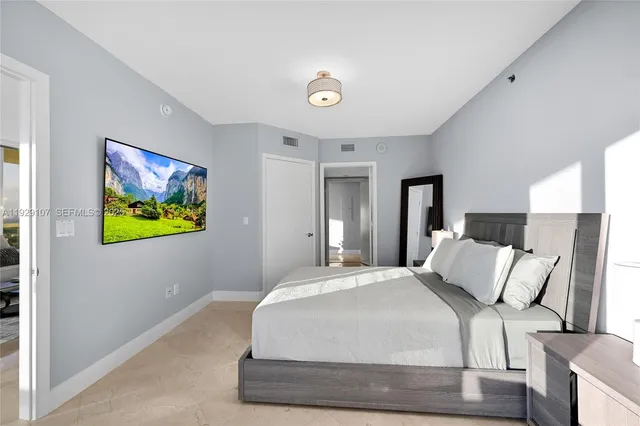 a bedroom with a bed and painting on the wall