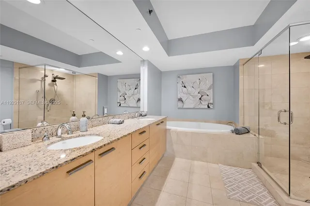 a spacious bathroom with a granite countertop tub sink a mirror a shower and vanity