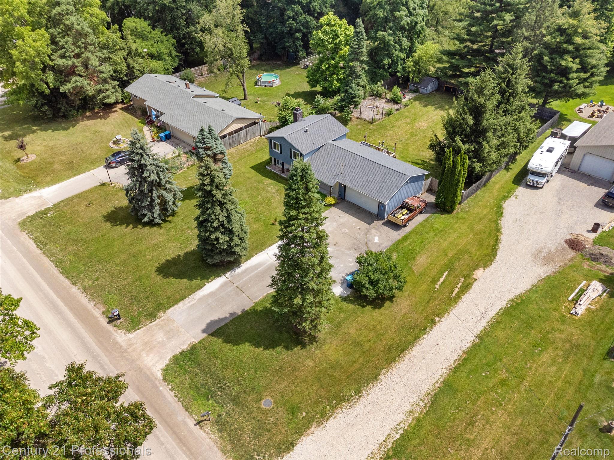 15037 Hogan Road Linden, MI 48451 - Photo 34 of 38 Aerial perspective highlighting two residential structures, extensive green space, mature trees, and an asphalt driveway