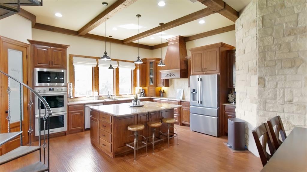 7421 Dawn Avenue Pilot Point, TX 76258 - Photo 14 of 40 a kitchen with stainless steel appliances granite countertop a refrigerator a stove top oven a sink dishwasher and white cabinets with wooden floor