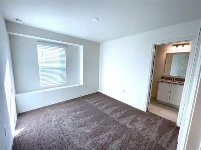 a view of an empty room with closet and a window