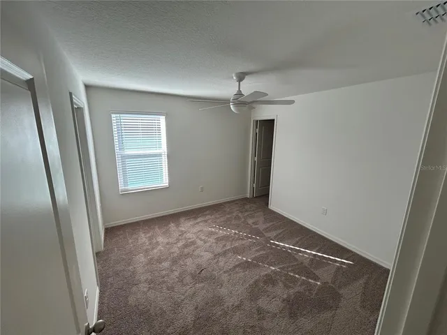 an empty room with windows and cabinet