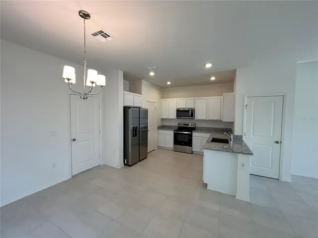 a open kitchen with refrigerator stove microwave and cabinets