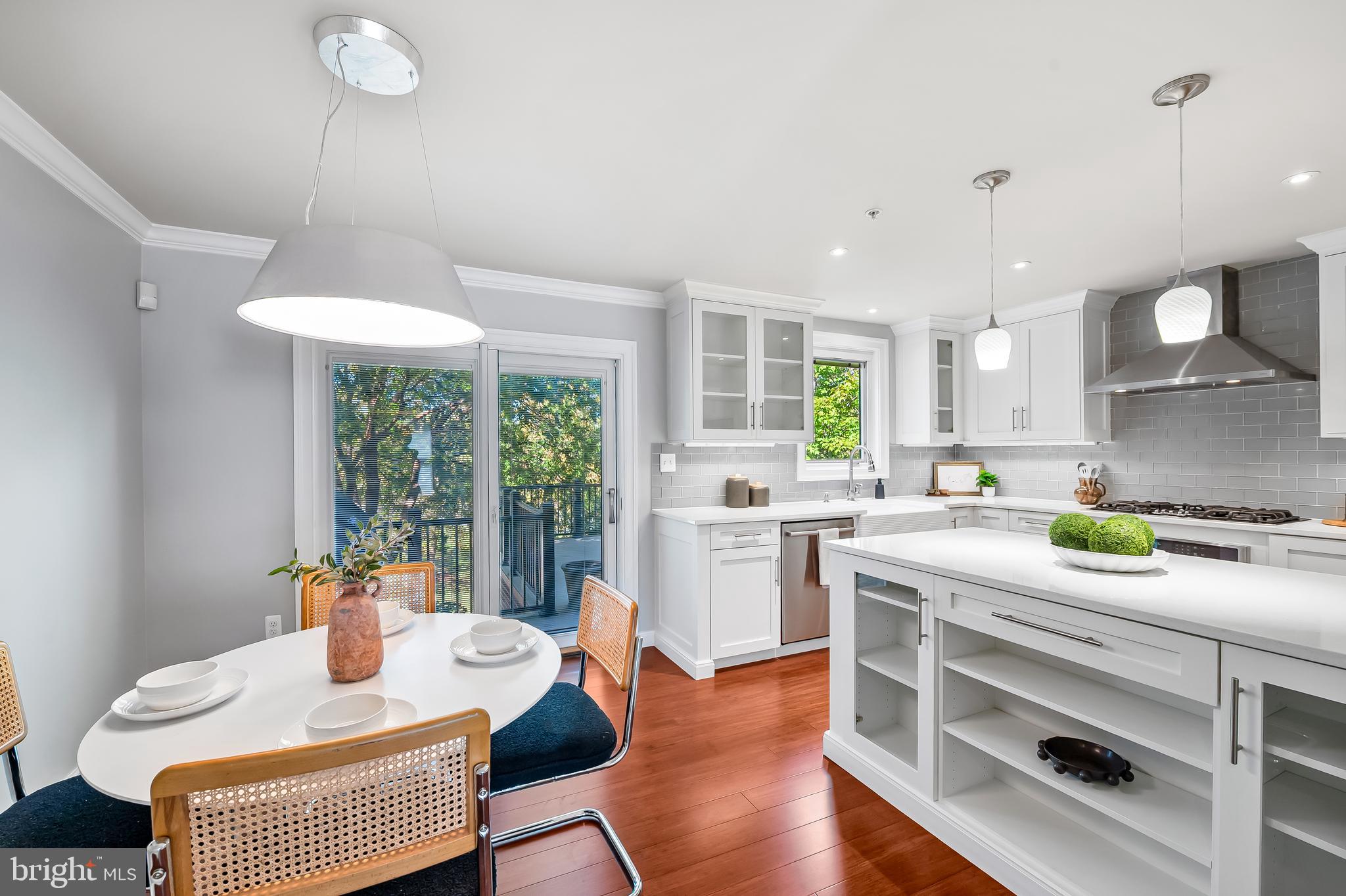 254 Robert Street Baltimore, MD 21217 - Photo 13 of 31 a kitchen with stainless steel appliances granite countertop a stove a sink dishwasher and a dining table with wooden floor