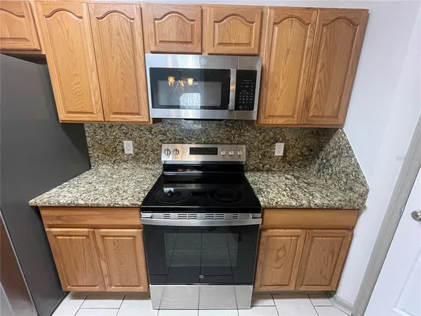 a kitchen with stainless steel appliances granite countertop a stove microwave and sink