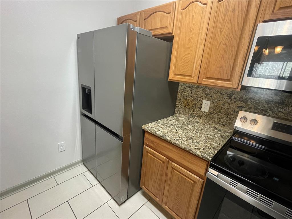 13548 Turtle Marsh Loop, Unit 427 Orlando, FL 32837 - Photo 4 of 34 a kitchen with stainless steel appliances granite countertop a refrigerator and a stove