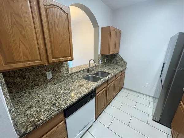 a kitchen with a granite countertop sink and a stove