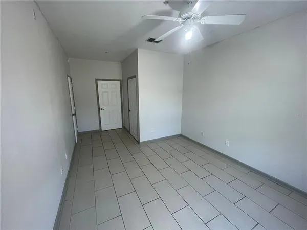 an empty room with a ceiling fan and carpet