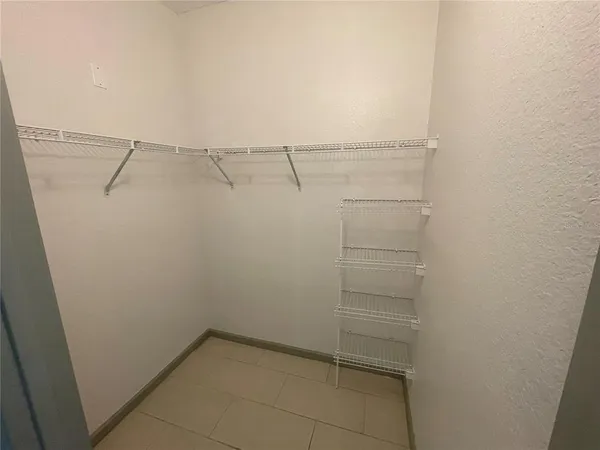 a view of walk in closet with empty racks