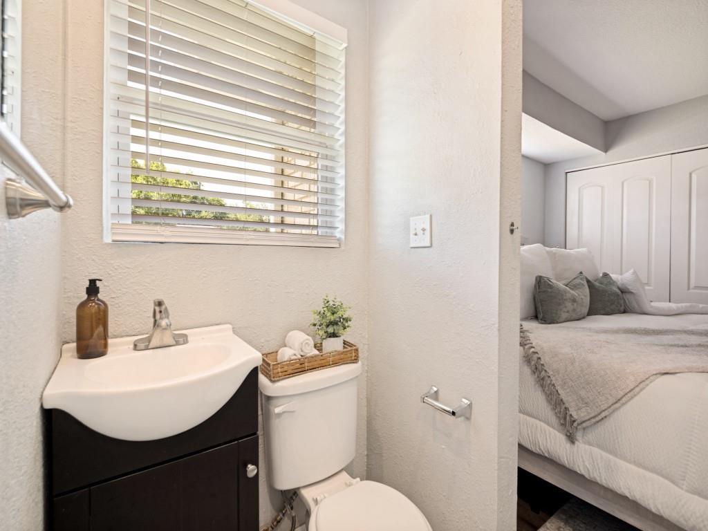1405 Rambler Road Arlington, TX 76014 - Photo 18 of 26 Compact powder room featuring a corner vanity with an integrated sink and a window with horizontal blinds