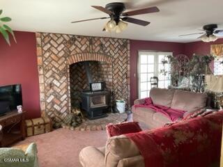 23381 Angus Court Tehachapi, CA 93561 - Photo 3 of 8 a living room with furniture a fireplace and a flat screen tv