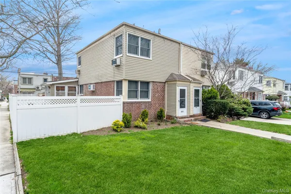 a front view of a house with a yard and trees