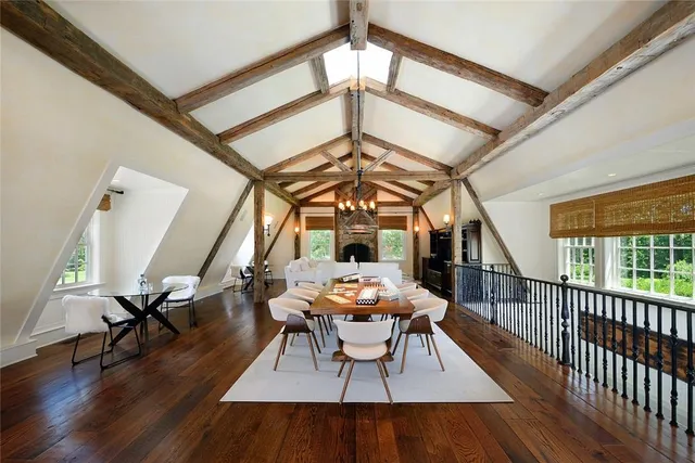 a dining room with wooden floor a chandelier a glass table and chairs