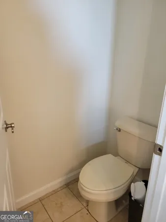 a white toilet sitting next to a white wall