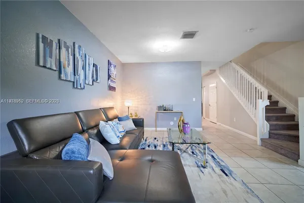 a living room with furniture and stairs