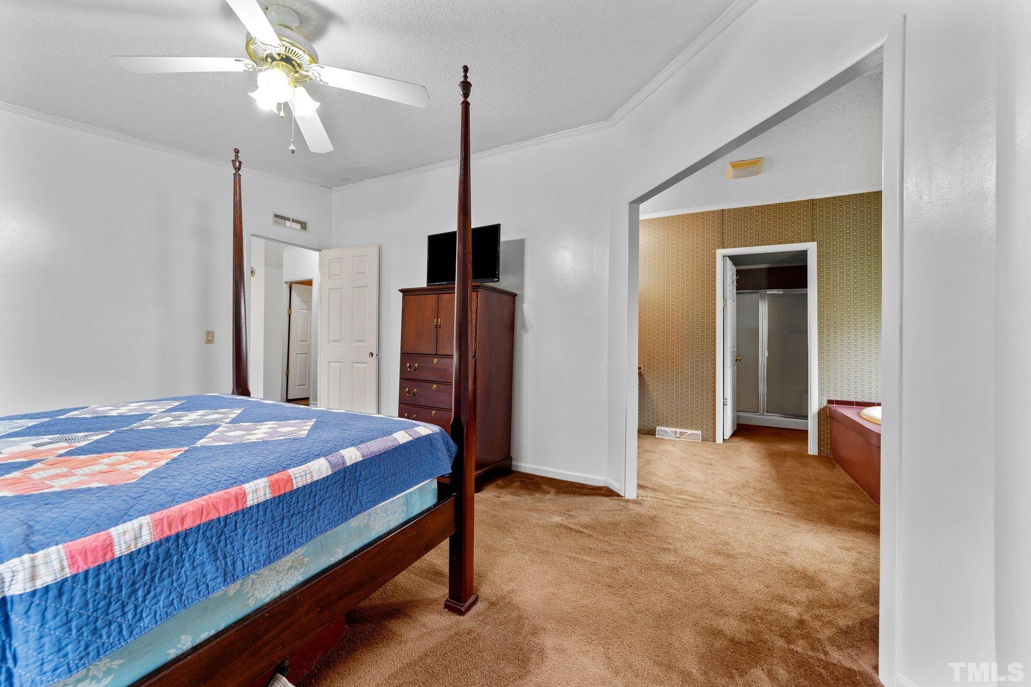 9617 Jernigan Road Spring Hope, NC 27882 - Photo 23 of 41 a bedroom with a bed and a chandelier